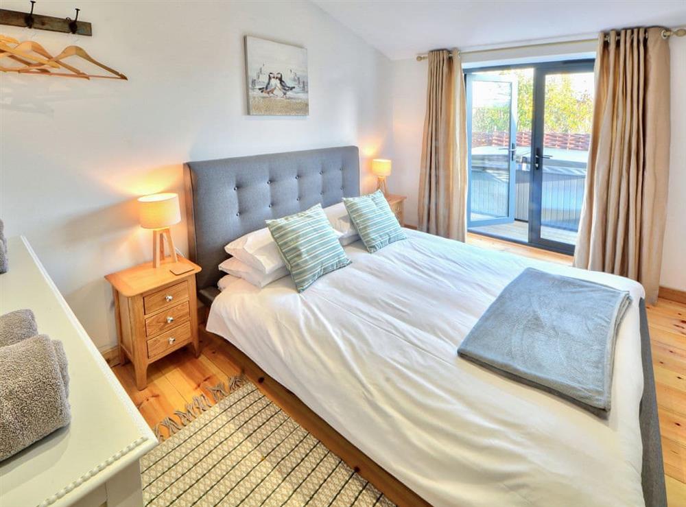 Sumptuous double bedroom with French doors leading to decking at Dornfelder, 
