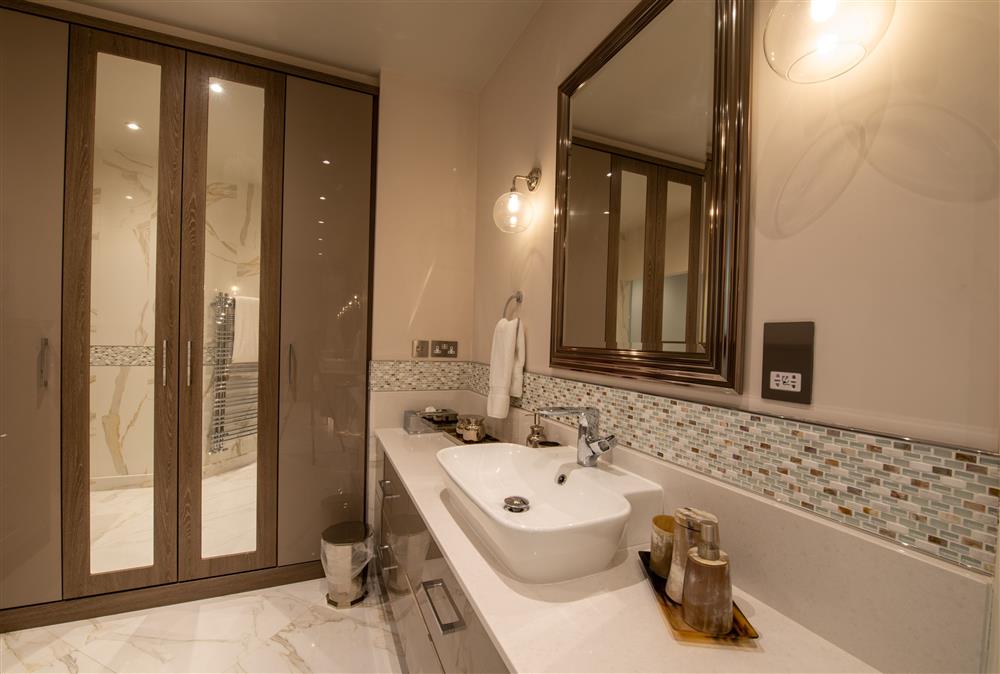 This extensive en-suite dressing room has ample storage space and luxurious steam shower