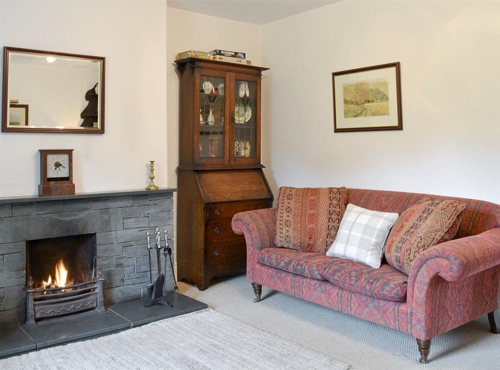 Spacious living room with an open fire at Roundhill Cottages 1 in Ambleside, Cumbria