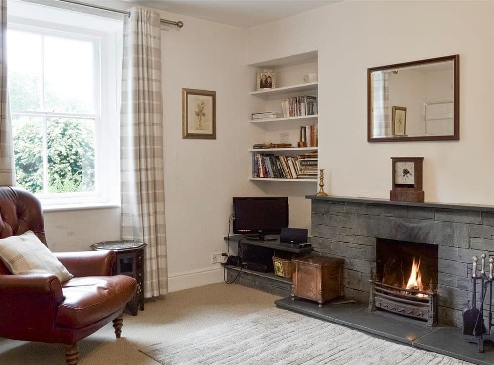 Warm and welcoming living room with feature fireplace at Roundhill Cottages 1 in Ambleside, Cumbria