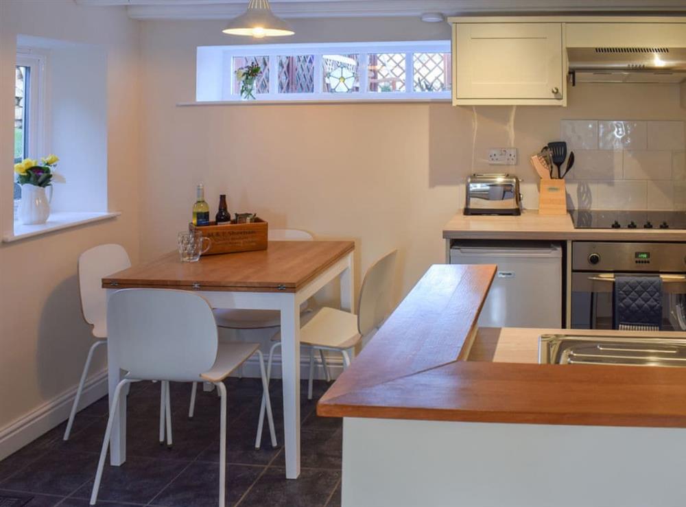 Compact dining area and adjacent kitchen at Rowan Cottage in Aislaby, near Whitby, Yorkshire, North Yorkshire