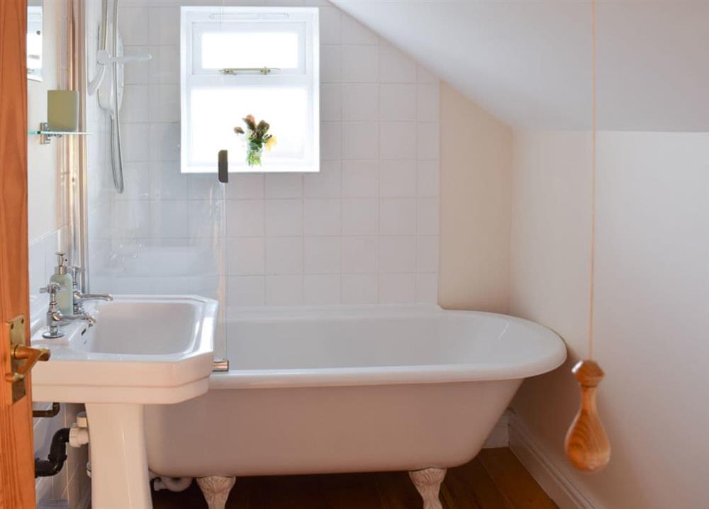 Lovely bathroom with standalone bath with shower overhead at Rowan Cottage in Aislaby, near Whitby, Yorkshire, North Yorkshire