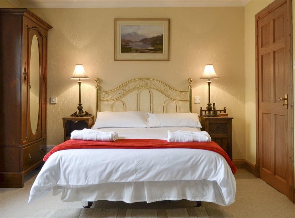 Stylish double bedroom with en-suite access to the bathroom at Rowan Cottage in Aviemore, Inverness-Shire