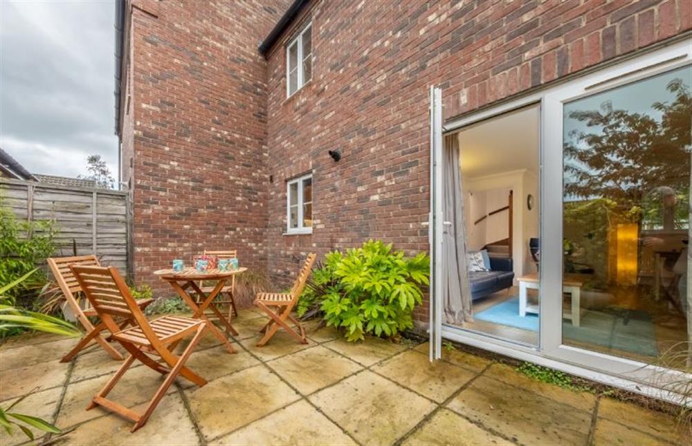 Enclosed courtyard to the rear with garden furniture at Rowan Cottage, Holt