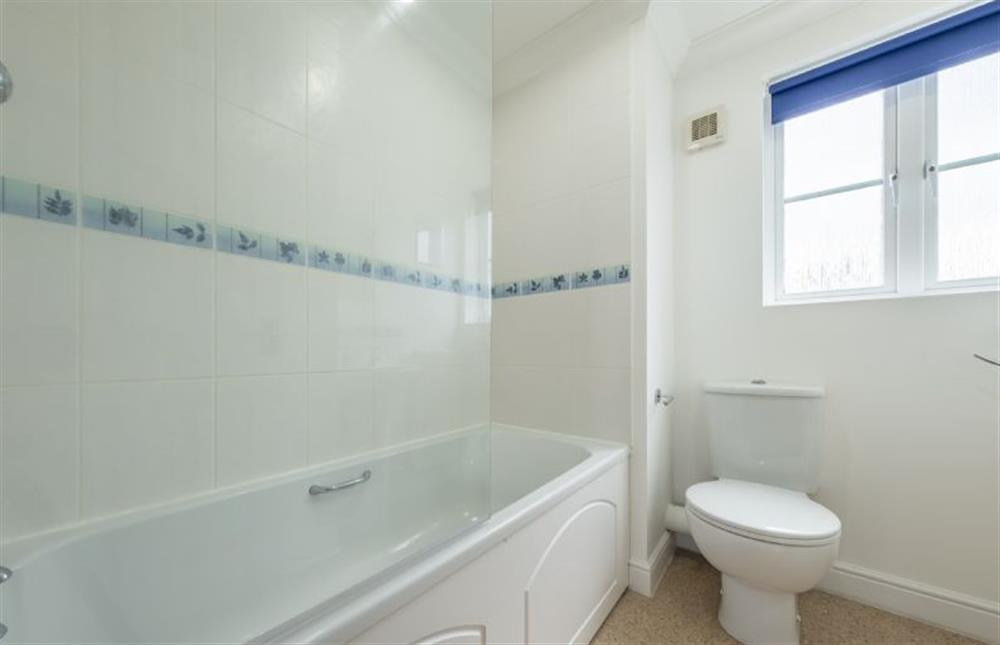 First floor: En-suite with bath with shower over, wash basin and WC at Rowan Cottage, Holt