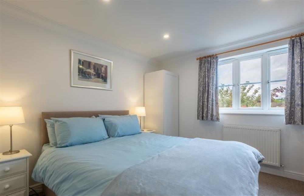 First floor: Master bedroom with a king-size bed at Rowan Cottage, Holt
