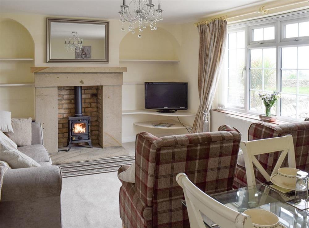 Welcoming living and dining room with wood burner at Rudda Farm Cottage, 