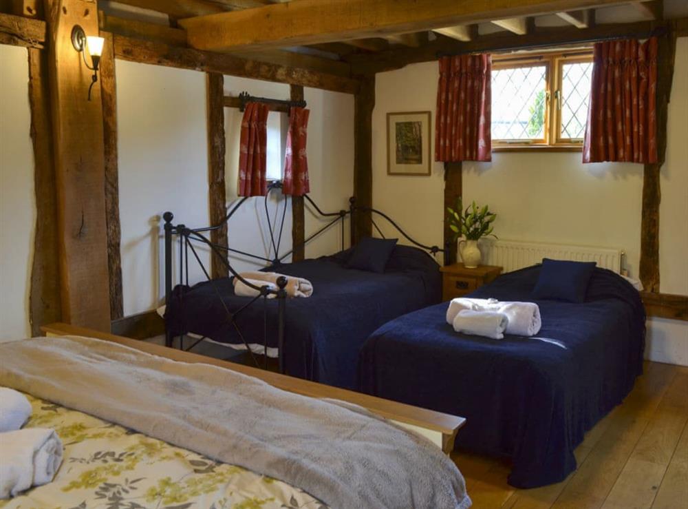 Spacious bedroom with double bed and two single beds (photo 2) at Rumbolds Retreat, 