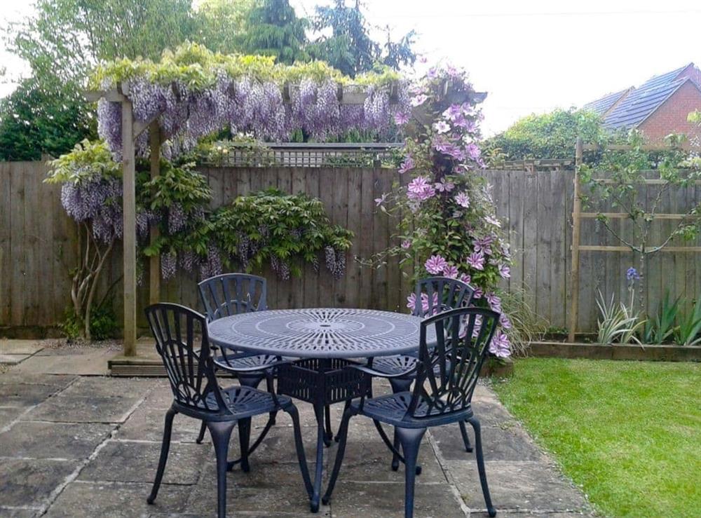 Sunny paved patio with furniture at Russet Cottage in Moreton-in-Marsh, Gloucestershire