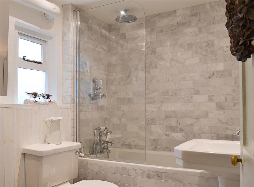 Part tiled bathroom with shower over the bath at Sage Cottage in St Columb Major, Cornwall