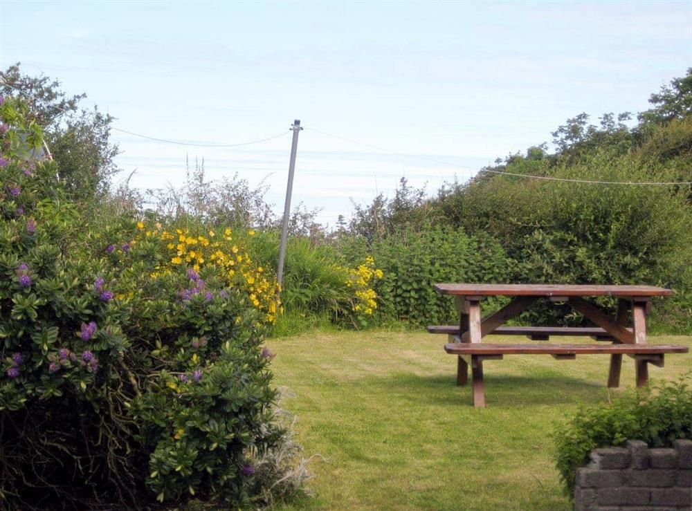 Lawned rear garden with sitting out area at Salfur in Rhiw, near Pwllhelli, Gwynedd