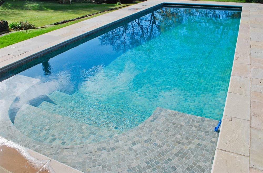 Tiled outdoor heated swimming pool at Salters Cottage in Boldre, near Lymington, Hampshire