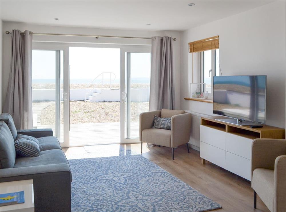 Stylish living area with patio doors to decked patio area at Salty Lodge in Hayling Island, Hampshire