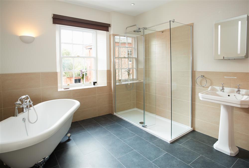 Bathroom with elegant roll top bath and separate shower at Salutation Apartment, Netherby Hall, Longtown
