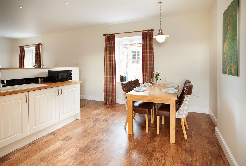 Dining area with seating for four guests at Salutation Apartment, Netherby Hall, Longtown