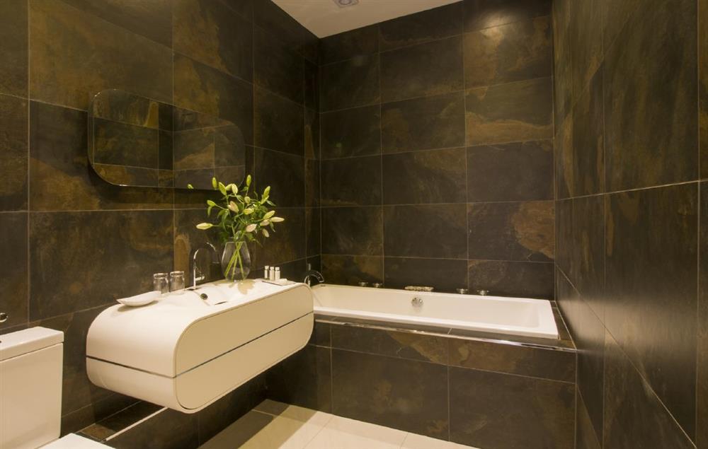 Beautiful family bathroom with spa bath and hand-held shower attachment at Sandfields Barn, Luddington