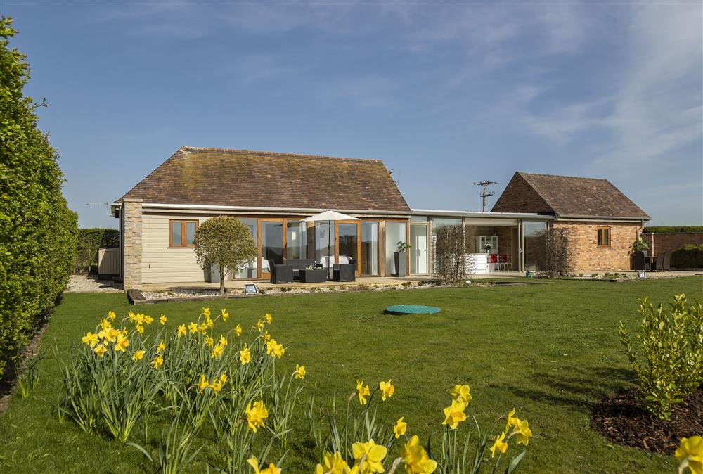 The delightful enclosed garden accessible from the many patio or bi-fold doors at Sandfields Barn, Luddington