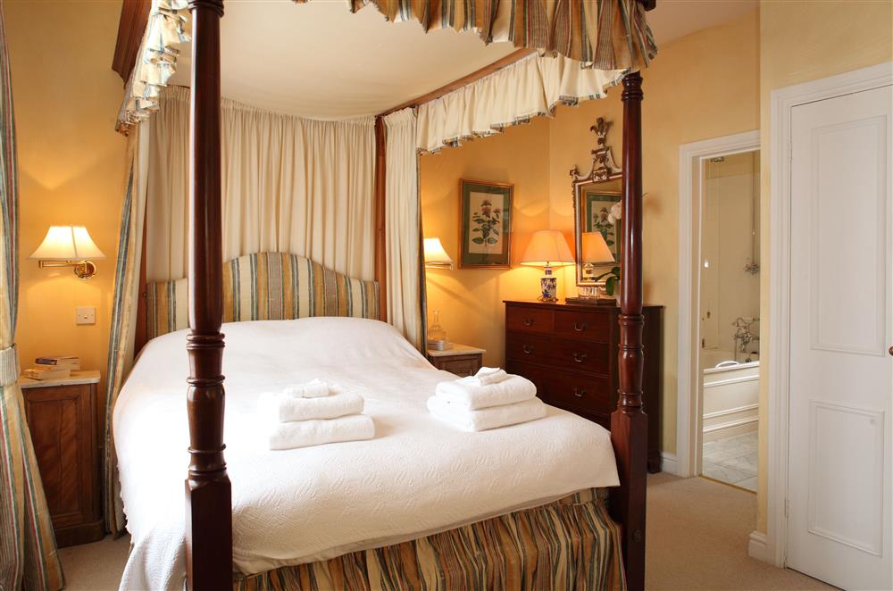 Bedroom one on the ground floor, with 4’6 four-poster double bed at Sandown Cottage, Bruern, near Chipping Norton