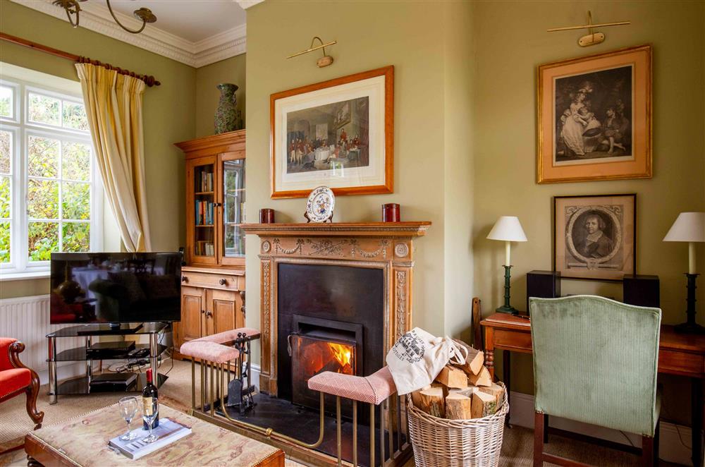 Relax in front of the open fire in the sitting area at Sandown Cottage, Bruern, near Chipping Norton