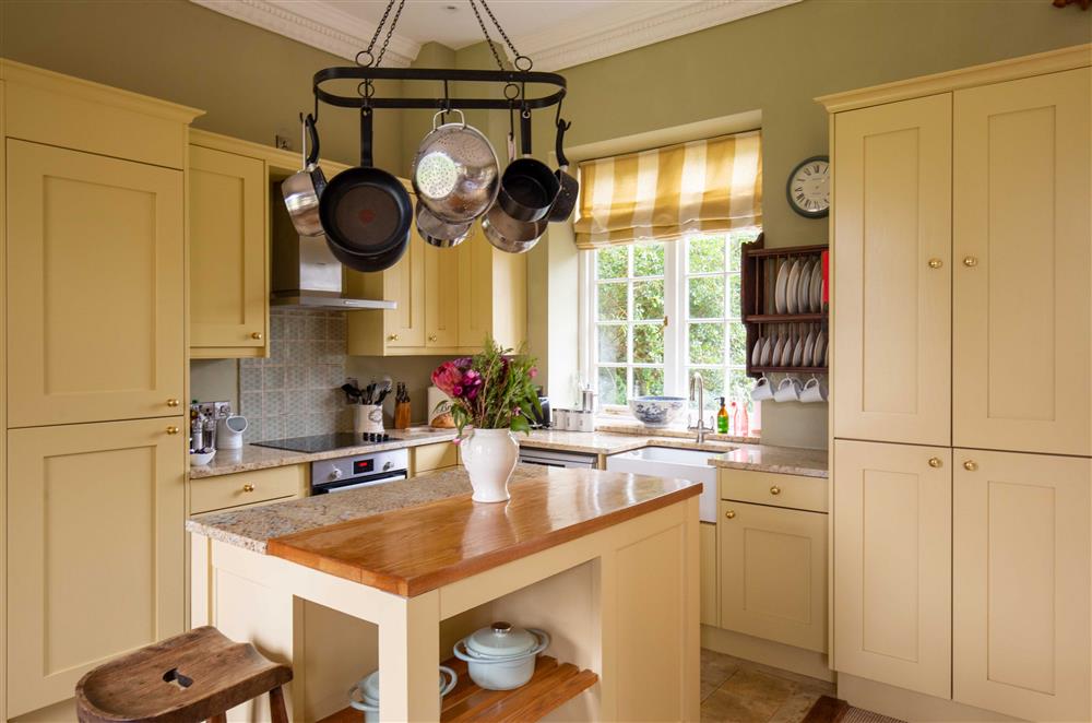 The kitchen boasts a center island, perfect for preparing meals together at Sandown Cottage, Bruern, near Chipping Norton