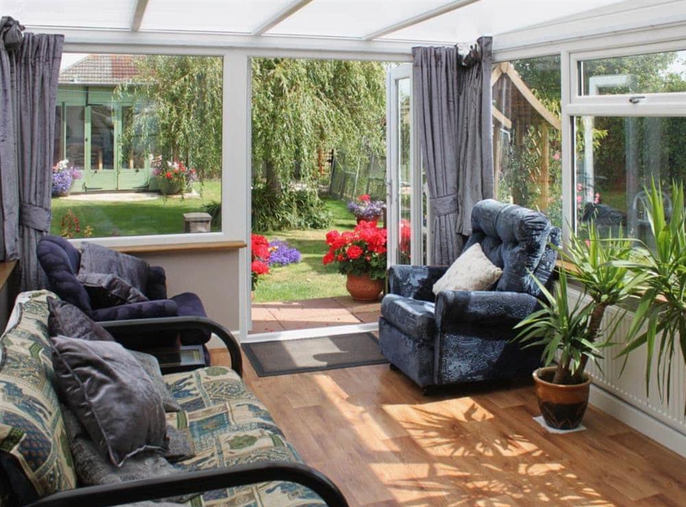 Sunny conservatory opening up onto the garden at Sandringham Heights in Paignton, Devon
