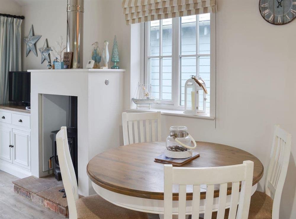 Compact dining area and adjacent fireplace at Sandy Bay Beach House in The Bay, Filey, North Yorkshire