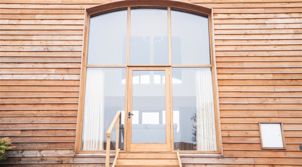 The double-height windows with door and steps down to the garden at Sandybury Barn in Bridgnorth, Shropshire