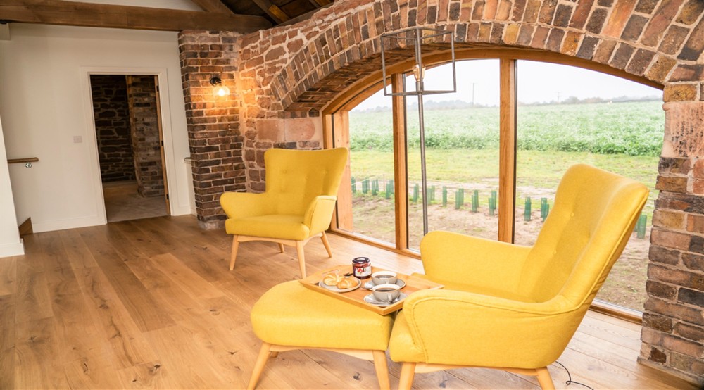 The first-floor mezzanine, with two armchairs, at Sandybury Barn in Bridgnorth, Shropshire