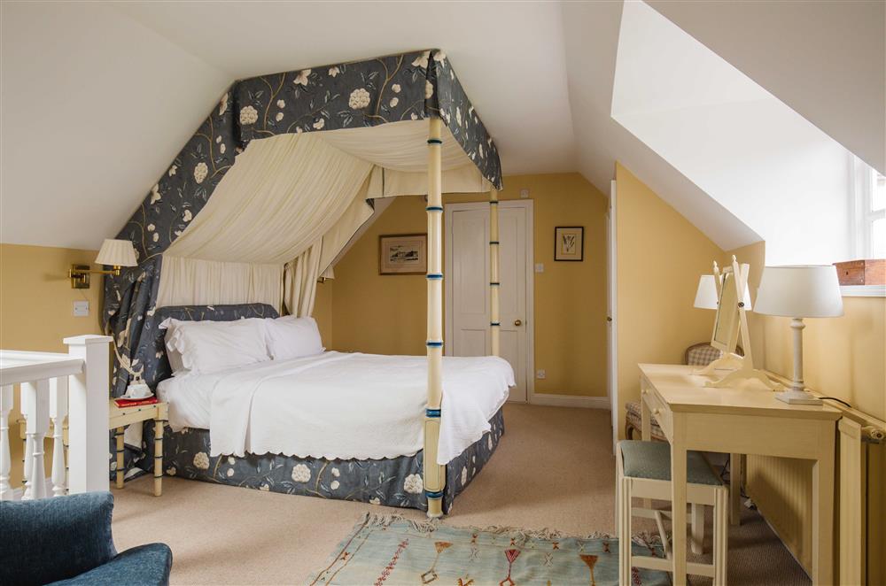 The bedroom, with a beautiful four-poster king-size bed  at Saratoga Cottage, Bruern, near Chipping Norton