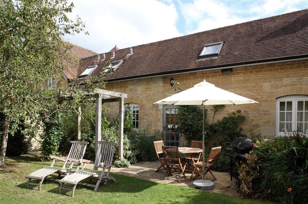 The garden is perfect for alfresco dining  at Saratoga Cottage, Bruern, near Chipping Norton