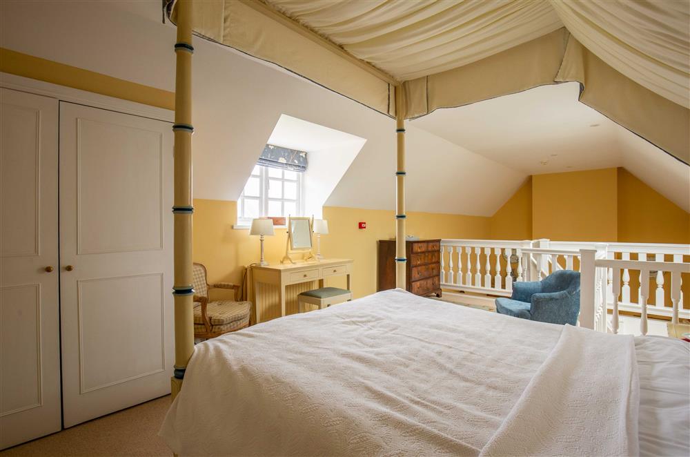 The spacious bedroom boasts an en-suite bathroom at Saratoga Cottage, Bruern, near Chipping Norton