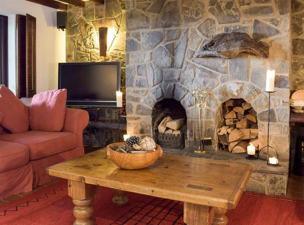 Living area with open fire & exposed stone fireplace at Sardis Cottage in near Kilgetty, Pembrokeshire, Dyfed