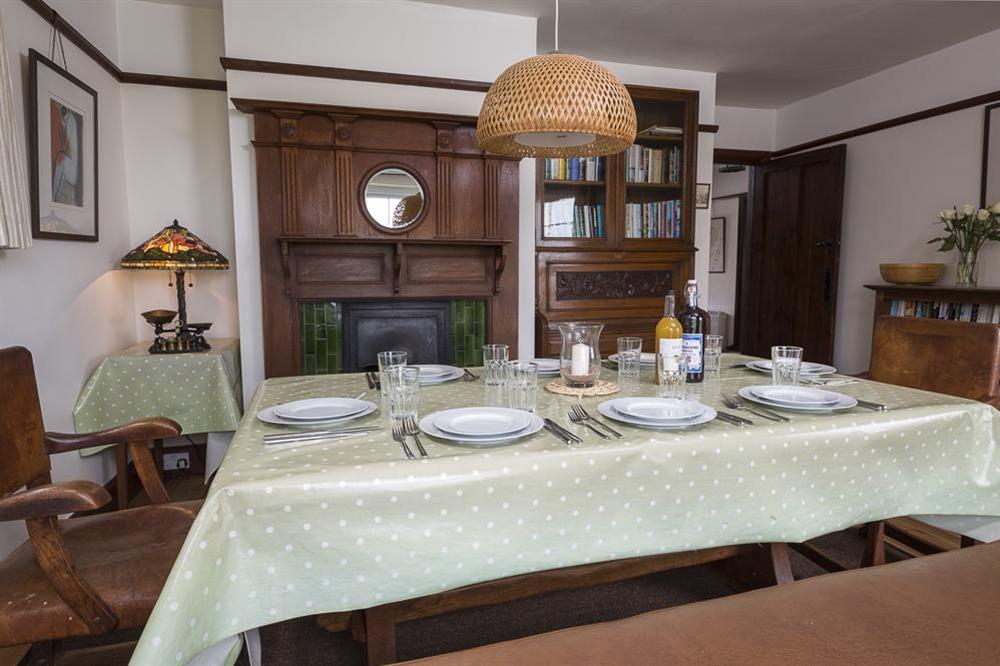 Dining room with large wooden table, chairs and bench seating at Savernake in , Thurlestone