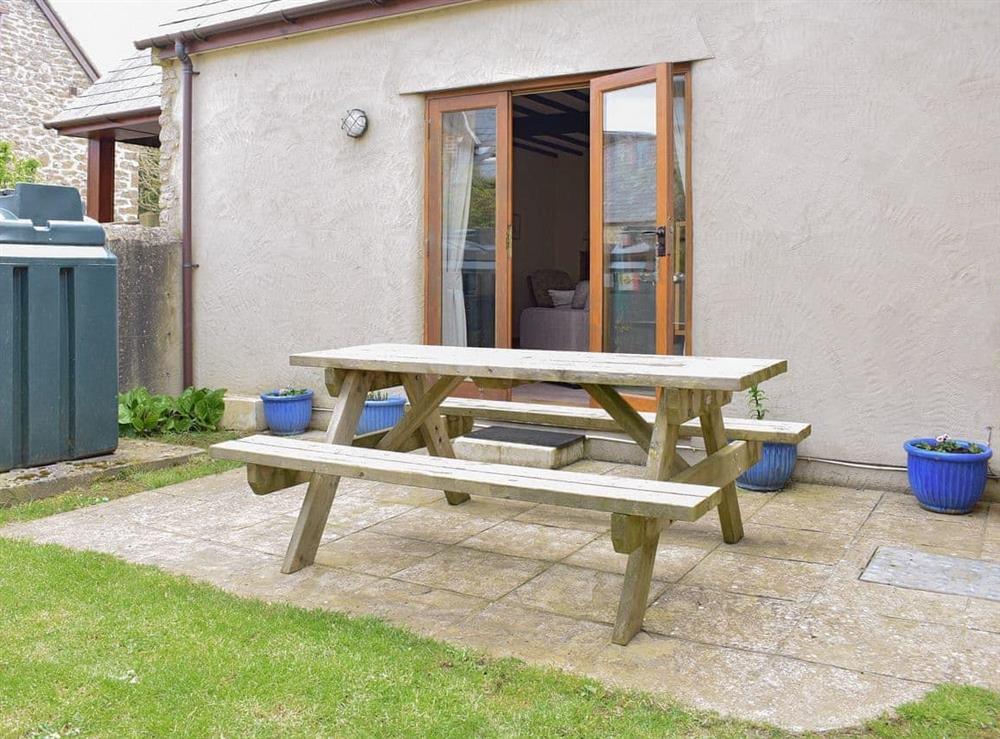 Paved patio area with outdoor furniture at Sawmill Cottage in Puncknowle, Dorchester., Dorset