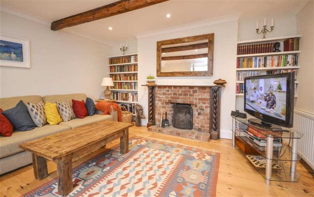 The lounge with open fireplace at School Cottage in Hope Cove