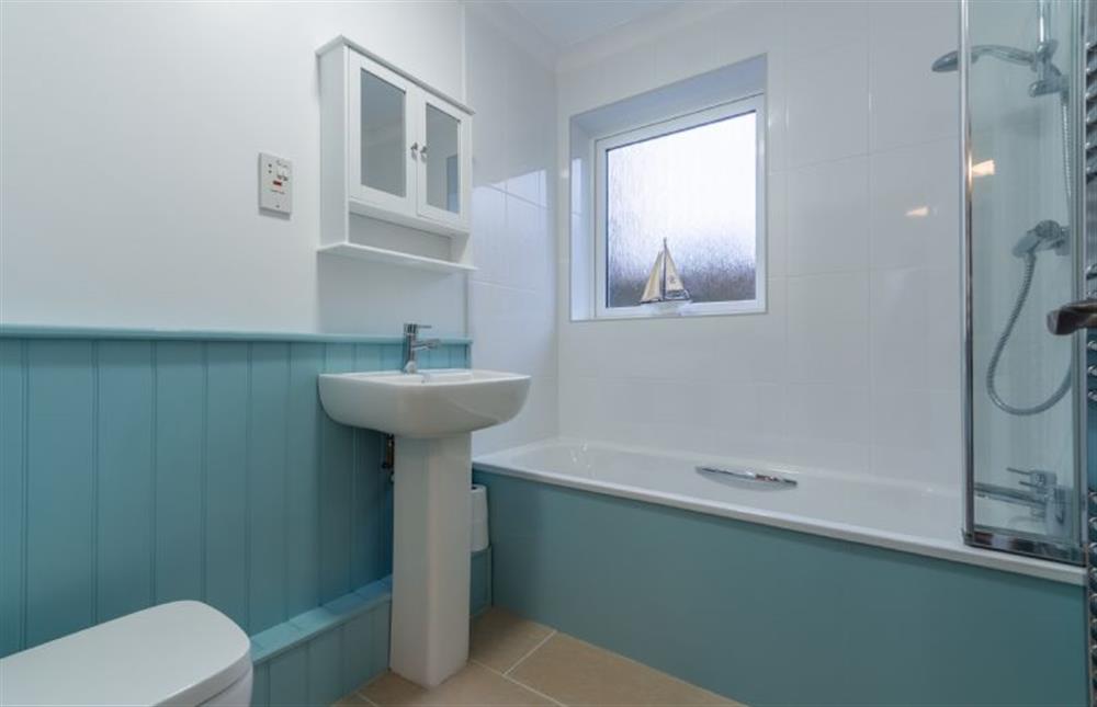 Ground floor: Bathroom with bath with shower over, wash basin, WC and heated towel rail at Sea Breeze, Brancaster near Kings Lynn