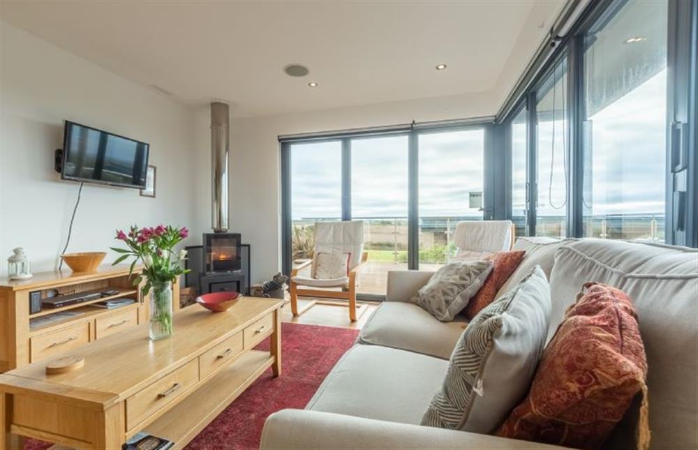 Sea Gem, St Agnes. Sitting area with a television and state-of-the-art wood burning stove. Bi-folding doors to deck (photo 2)