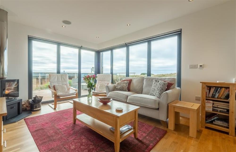 Sea Gem, St Agnes. Sitting area with a television and state-of-the-art wood burning stove. Bi-folding doors to deck
