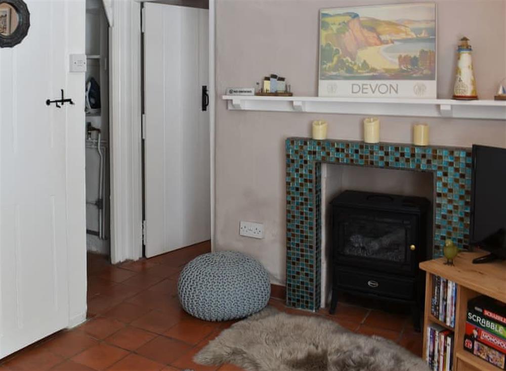 Charming feature fireplace and electric woodburner at Sea Glass Cottage in Holcombe, Dawlish, Devon