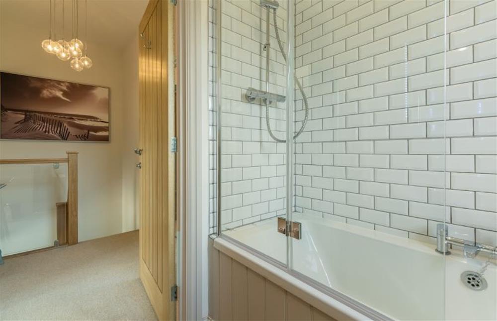 First floor: Family bathroom has bath with shower over at Sea Holly Cottage, Thornham near Hunstanton