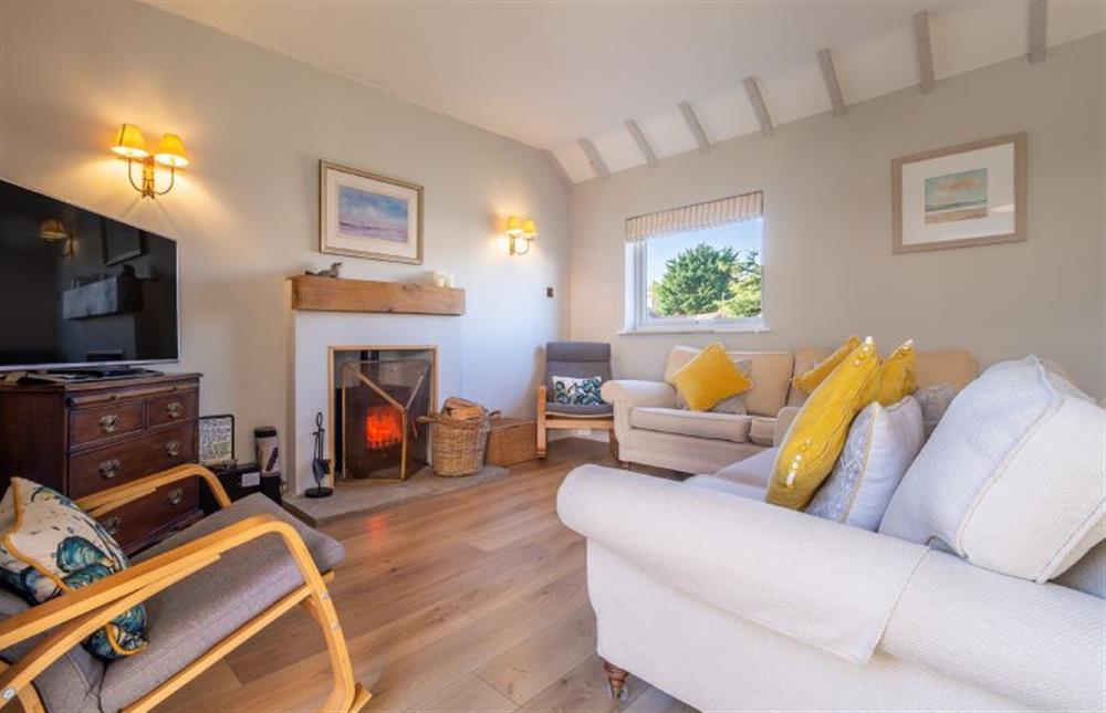 The sitting room has a cosy wood burning stove at Sea Lodge, Brancaster near Kings Lynn