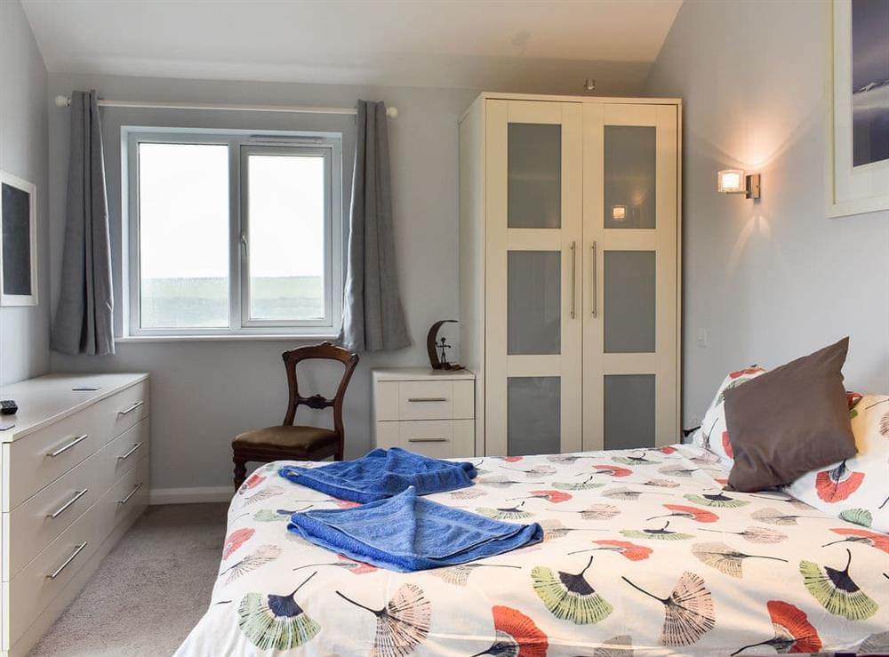 Comfortable double bedroom with Juliet balcony and en-suite at Sea Otter in Porthtowan, Cornwall