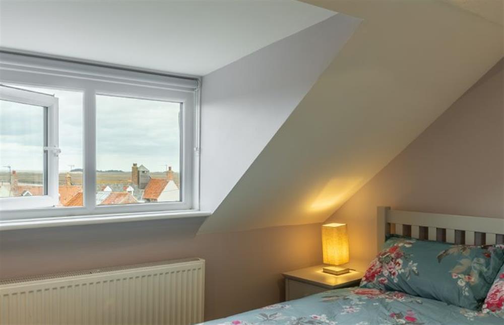 Second floor: Master bedroom with view of the coast across the roof tops at Sea Shanty Cottage, Wells-next-the-Sea