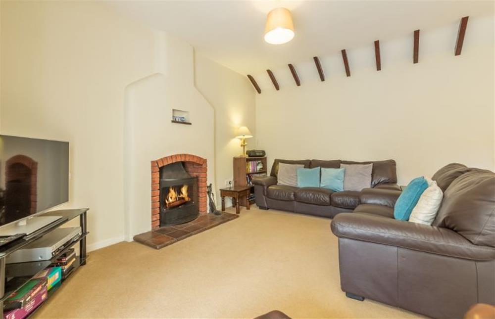 Ground floor: Comfortable leather sofas round the open fire at Sea Wind, Brancaster near Kings Lynn