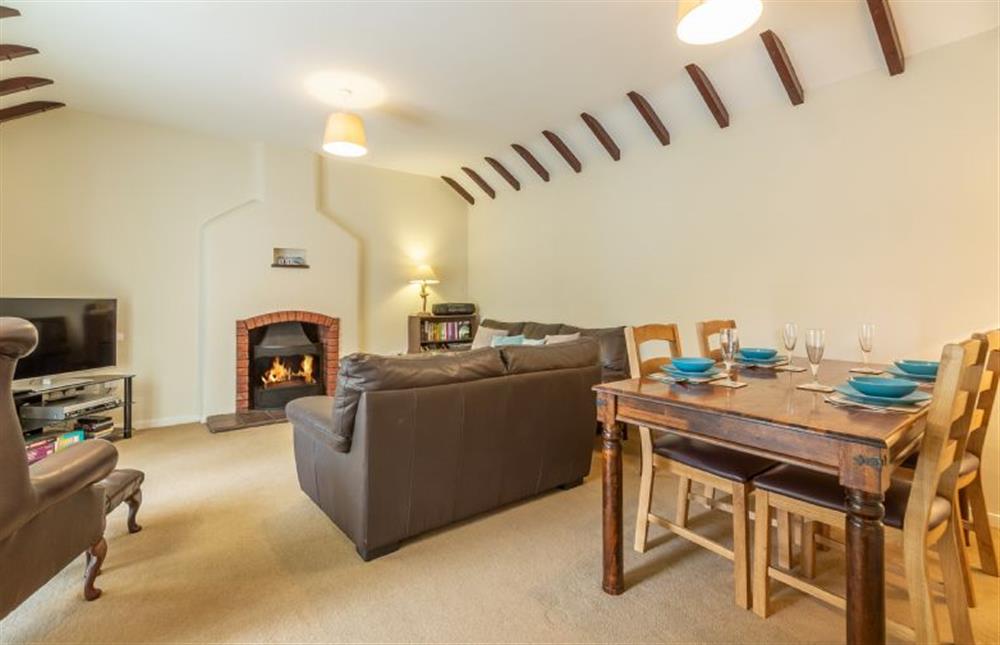 Ground floor: Open plan Siting / Dining room with an open fire at Sea Wind, Brancaster near Kings Lynn