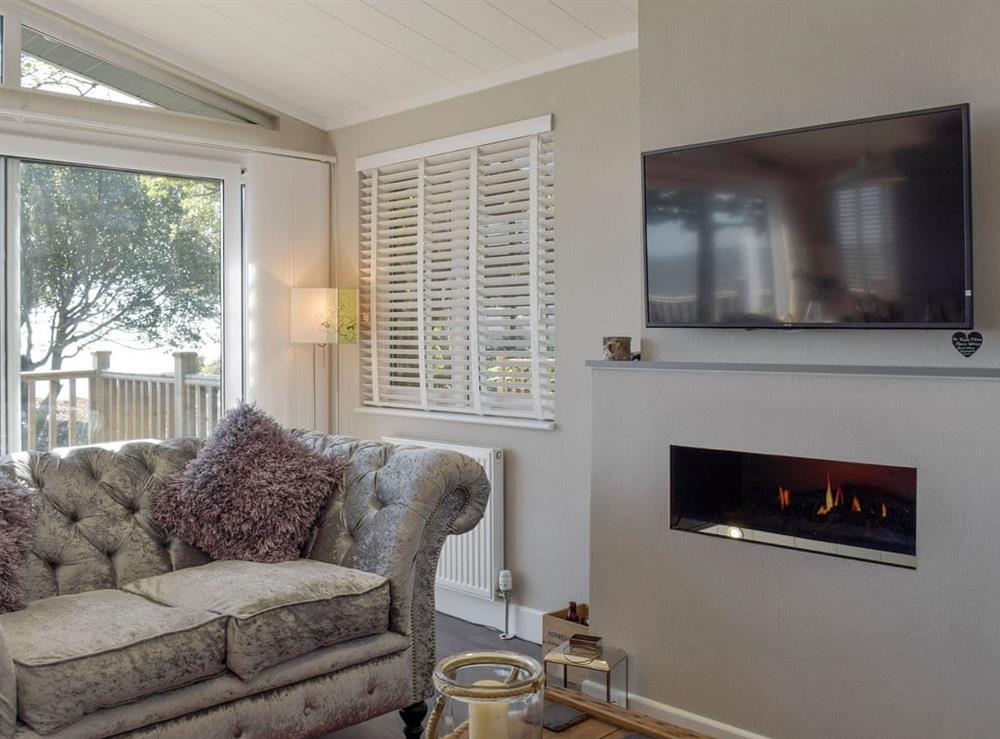 Wall-mounted fire and large TV in living area at Seacliff in Corton, near Lowestoft, Suffolk