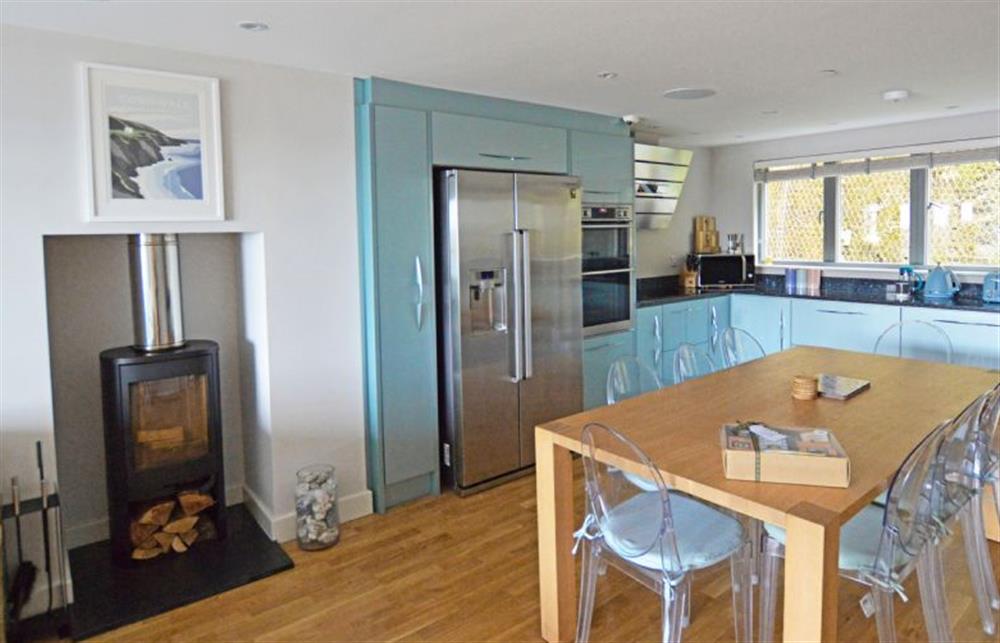 First floor: Open-plan kitchen and dining area with dining table and seating for eight guests at SeaEsta, Portreath