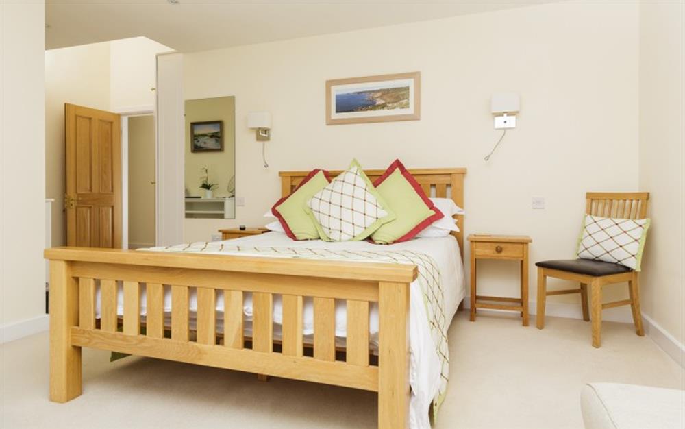Bedroom 1 with doors to the terrace and estuary views at Seaflowers in Frogmore
