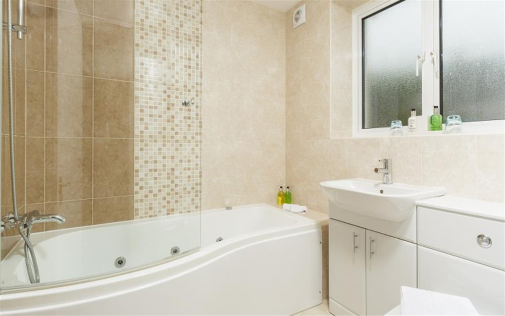 Bedroom 3 has an en suite bathroom with shower over the bath at Seaflowers in Frogmore