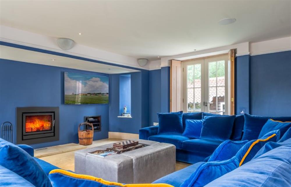 Sitting room with sumptuous sofa and wood-burning stove